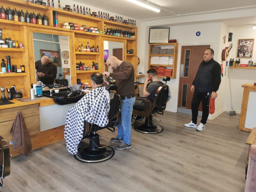 Inside Old Town Barbers with a barber cutting a customer’s hair