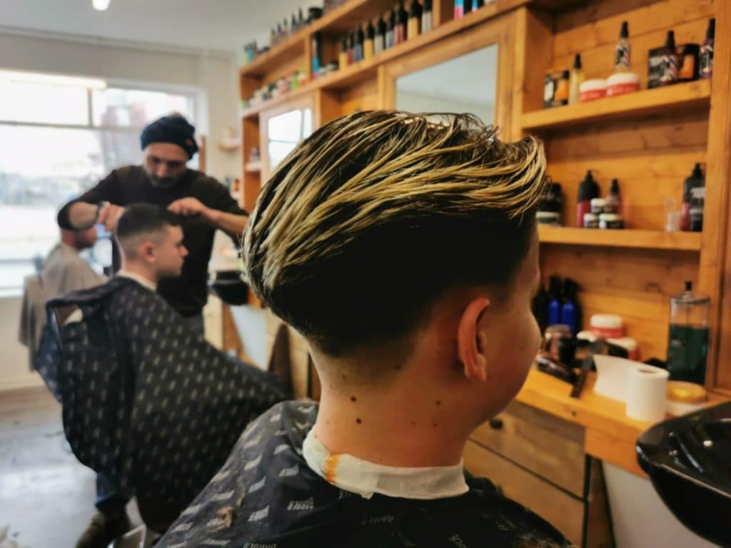 Textured fade haircut with blonde highlights